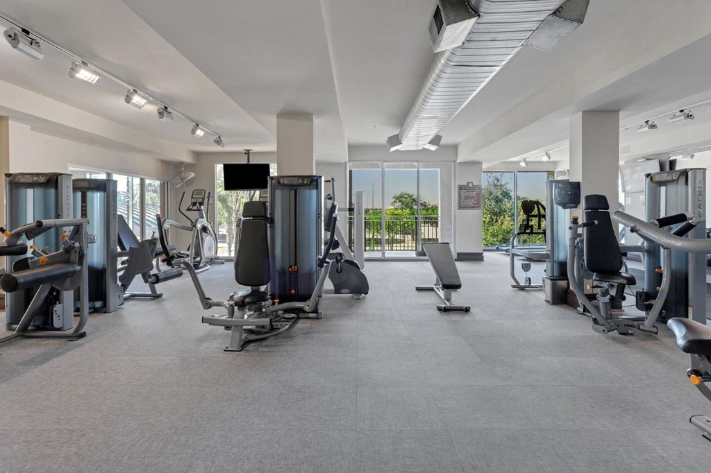 a gym with weights and cardio equipment in a building