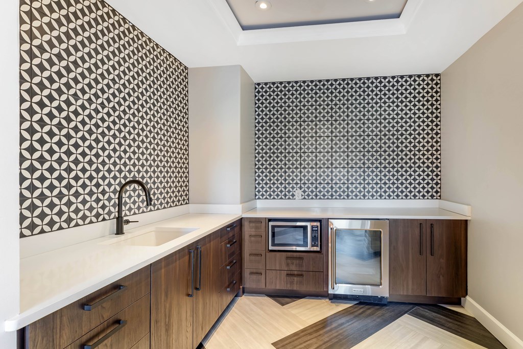 A kitchen with a patterned tile backsplash and wooden cabinets.