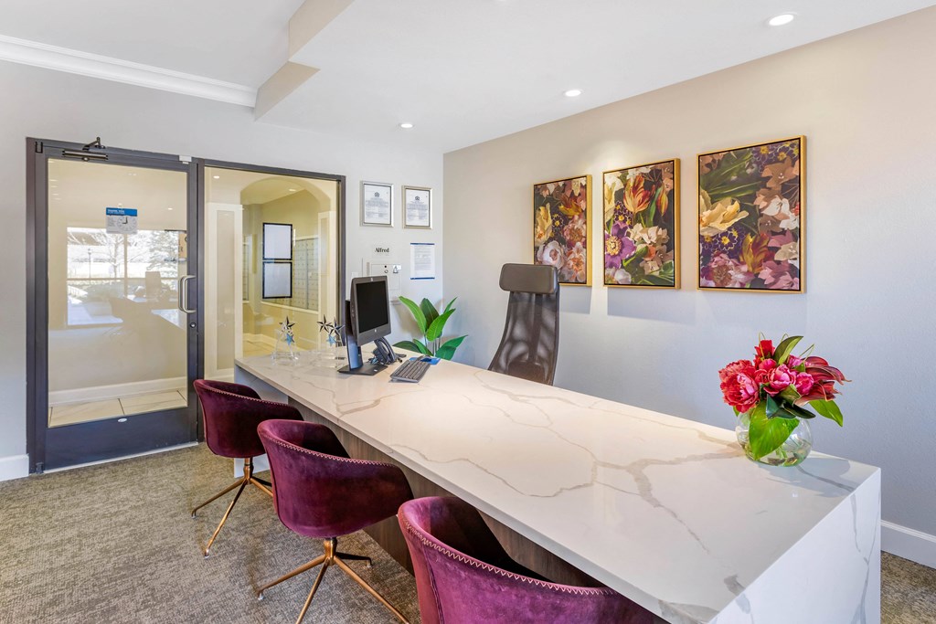 A conference room with a long table, chairs, and a vase of flowers.