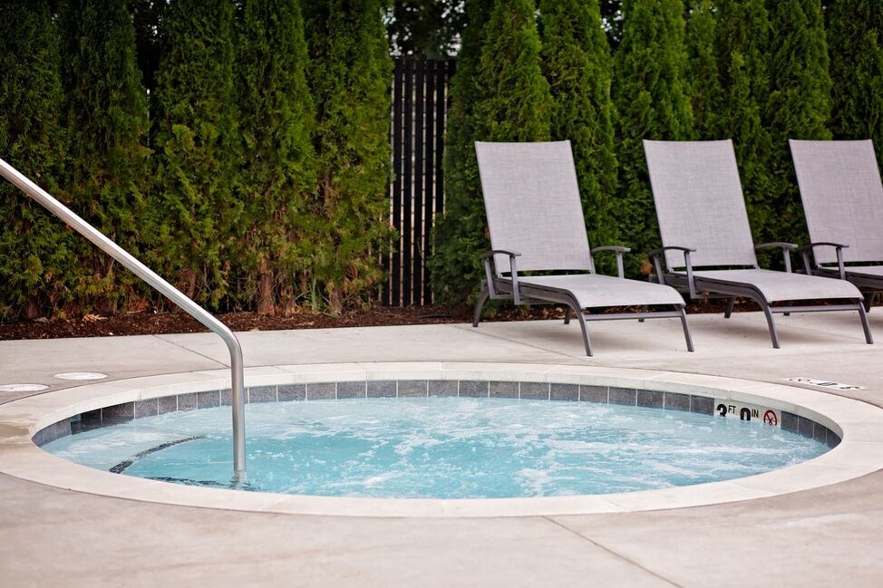 a hot tub with two chairs in the background