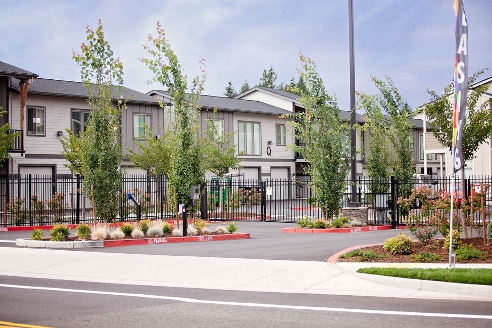 a street with a row of houses on the other side of a fence