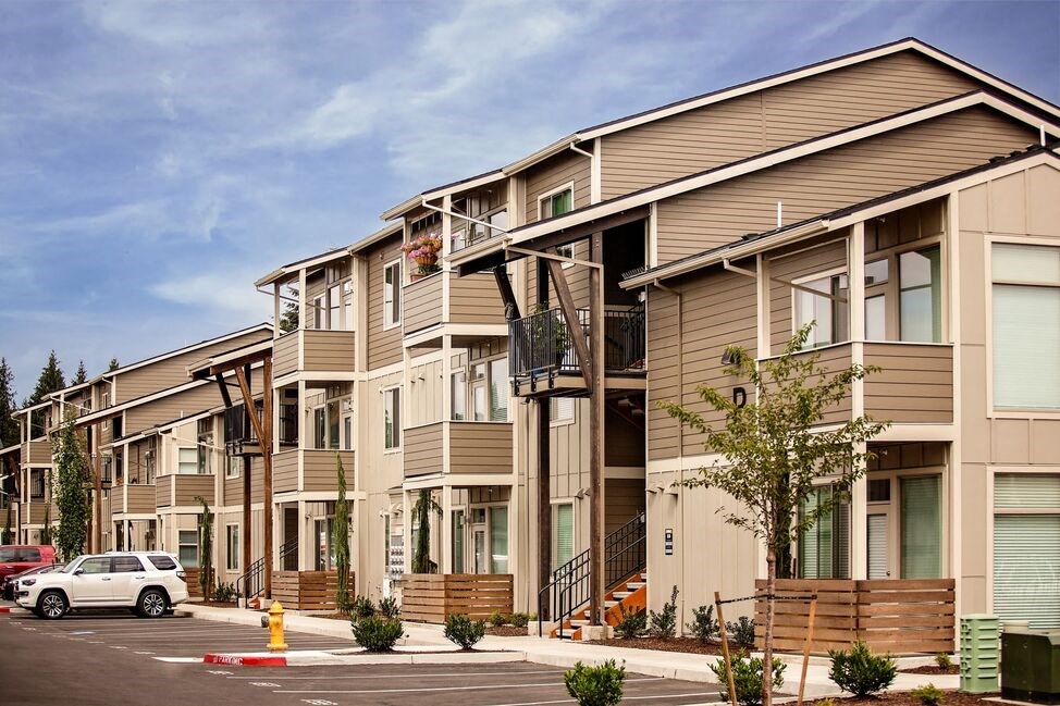 a row of townhomes with cars parked in front of them