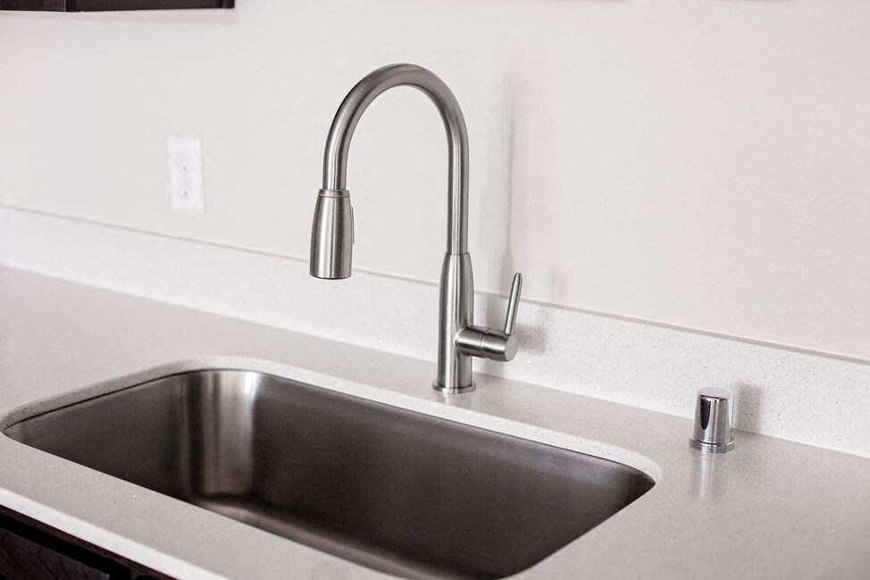 a kitchen sink with a chrome faucet