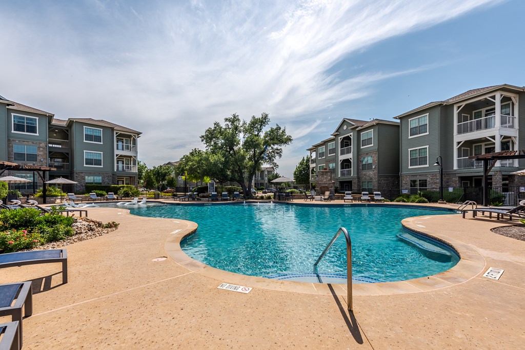 A pool with builings in the background.