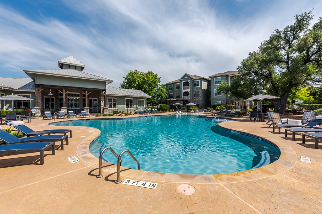 A large swimming pool with a building in the background.