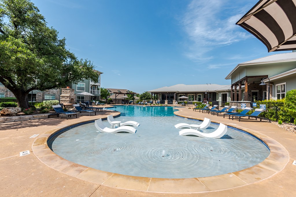 A large swimming pool with a water feature in the middle.