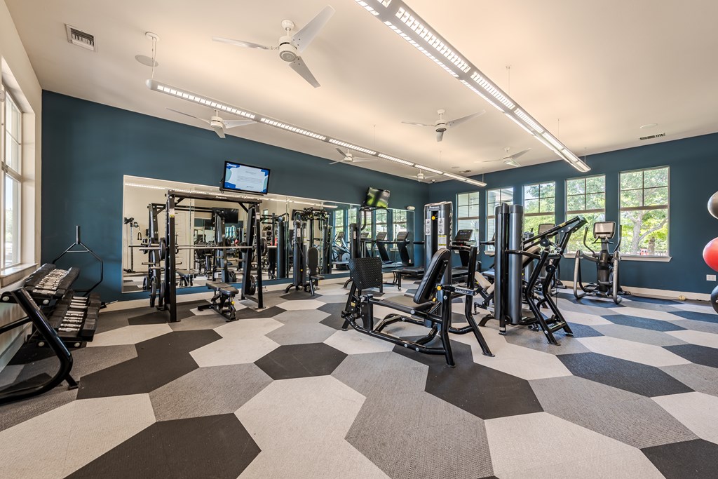 A gym with a variety of equipment and a checkered floor.