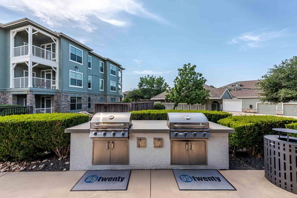 A bbq grill is in front of a building with a sign that says "twenty".