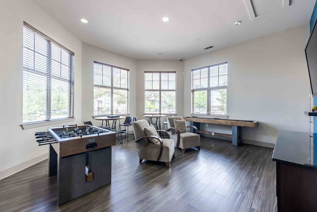 A modern kitchen with a large island and a dining area with chairs.