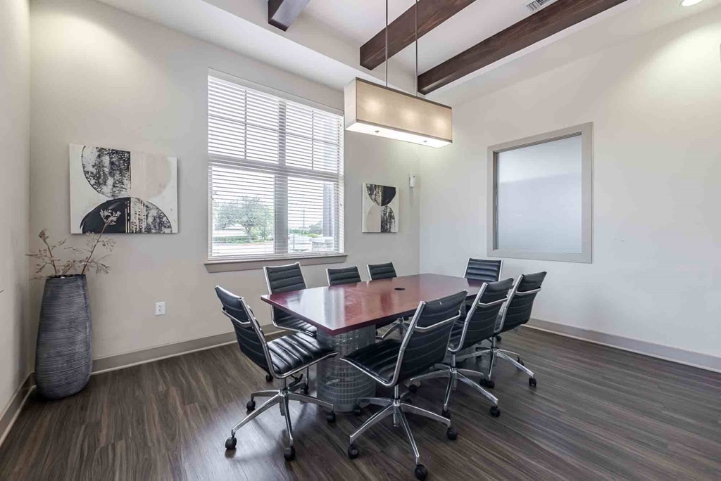 A conference room with a large table and chairs.