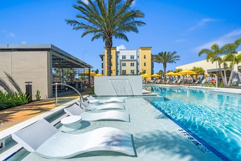 A pool with a slide and a building in the background.