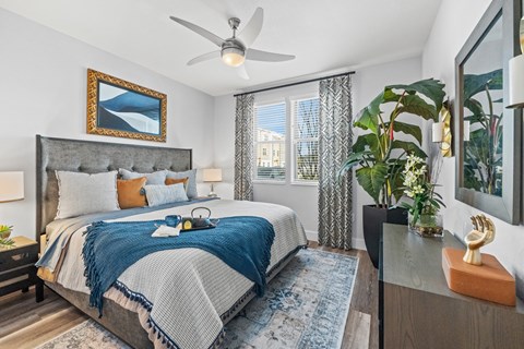 A bedroom with a large bed and a ceiling fan.