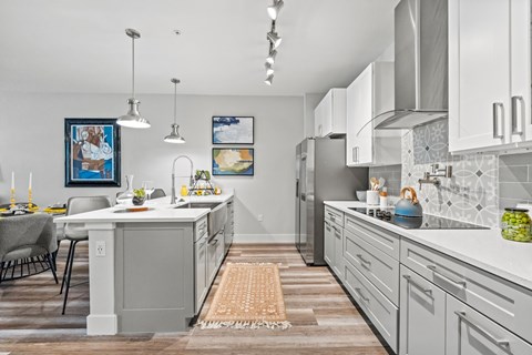 A kitchen with a table and chairs and a framed picture on the wall.