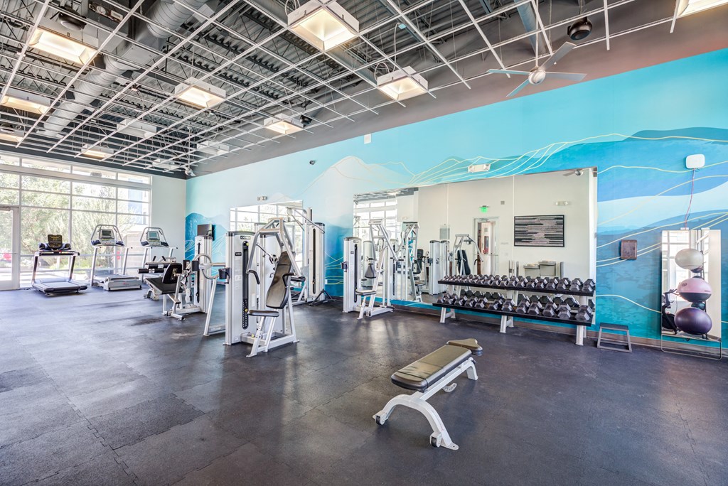 a view of the fitness center with cardio equipment and a mural of a mountain on the wall