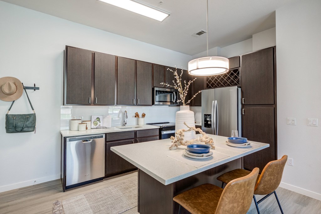 a kitchen with a large island and stainless steel appliances