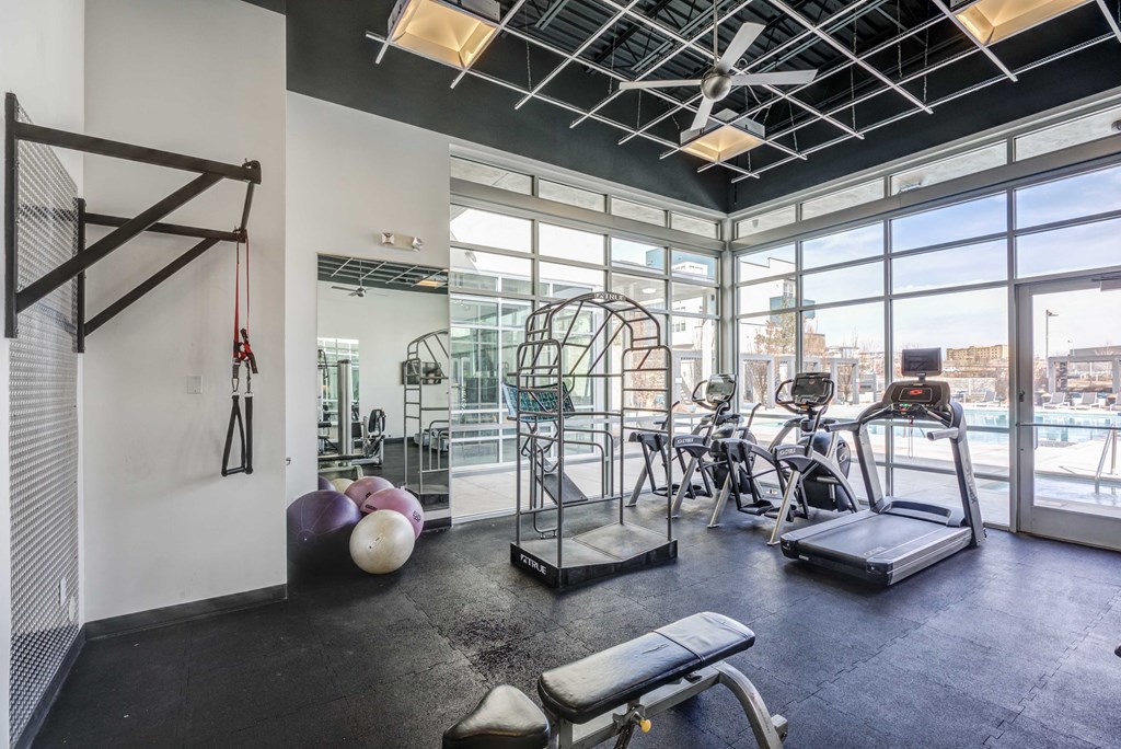 a workout room with a large window and exercise equipment