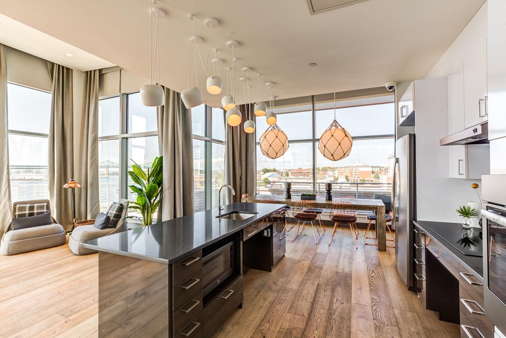 a kitchen with a large island and a living room with a table and chairs