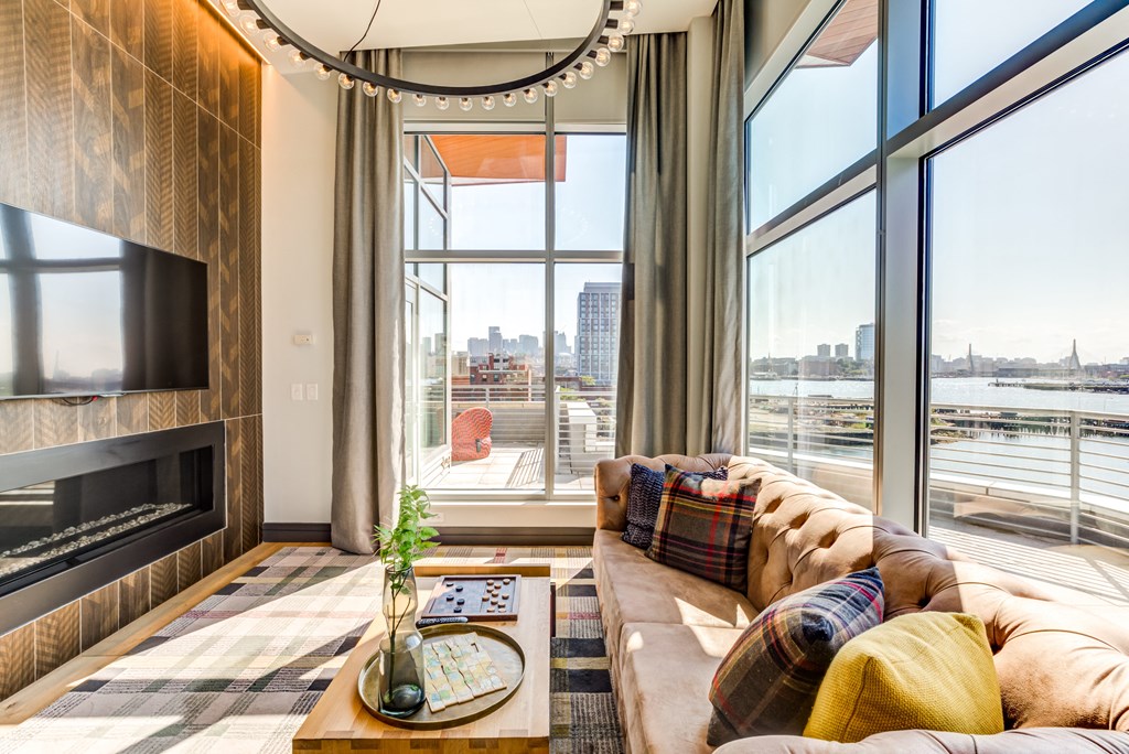 a living room with a large window and a couch and a fireplace