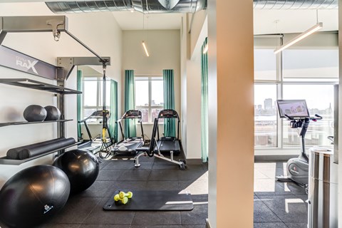 a gym with weights and other exercise equipment and windows