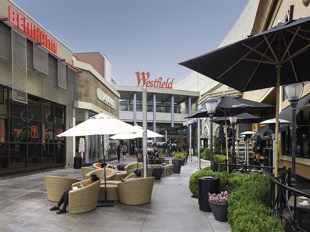 a person sitting on a couch under an umbrella