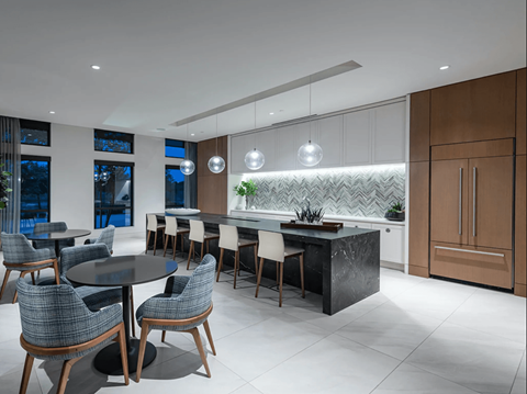 a kitchen with a large island with chairs and a table