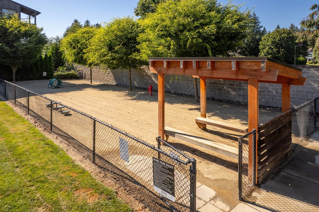 a dog park with a fenced in area and a bench