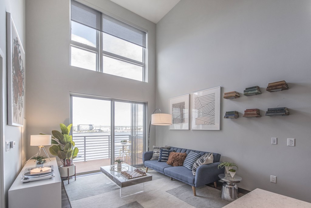 a living room with a blue couch and a large window