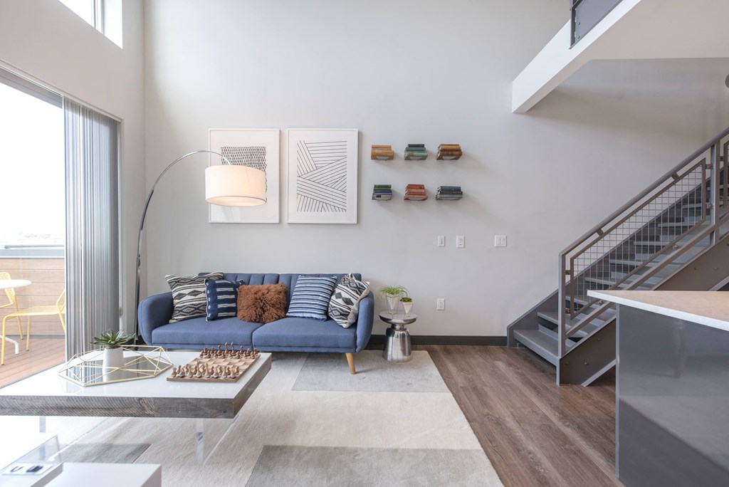 a living room with a blue couch and a staircase