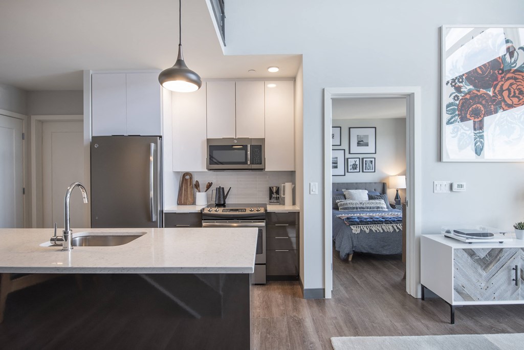 an open kitchen and living room with a bedroom in the background