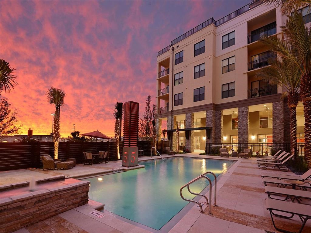 a swimming pool with a sunset in the background