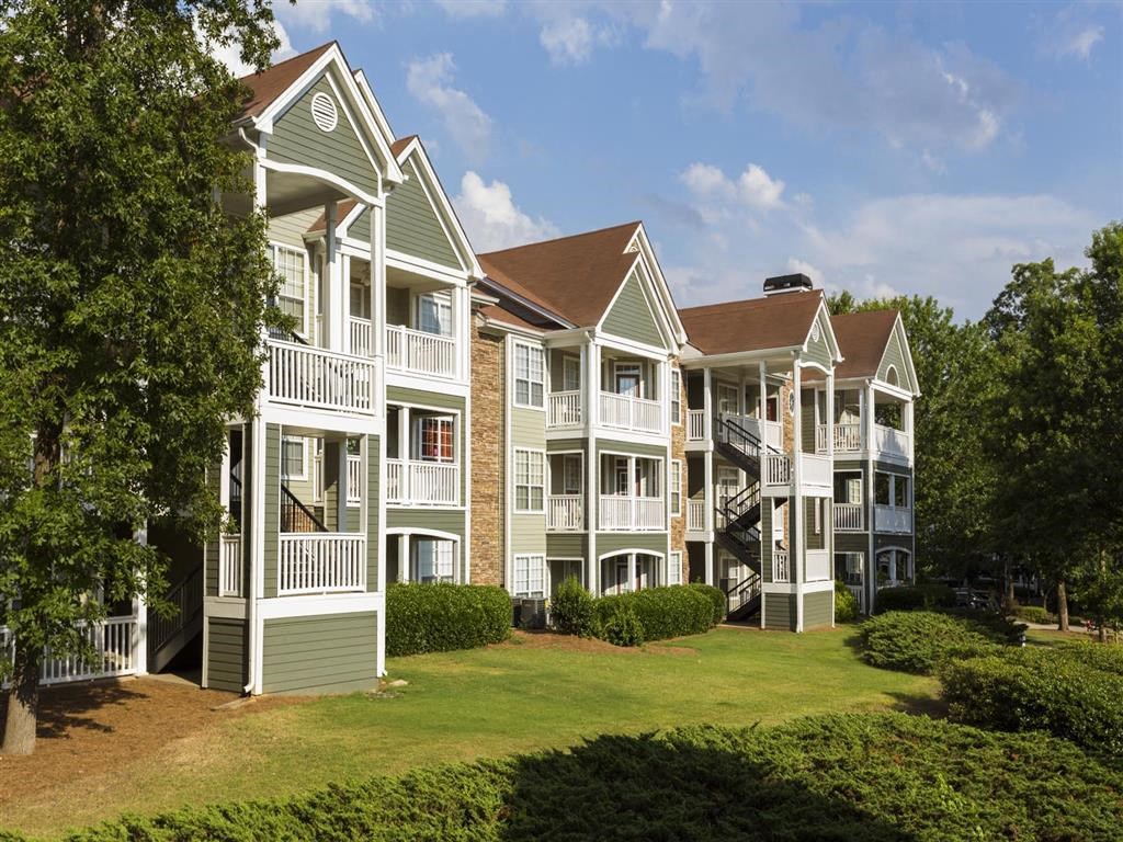 an exterior view of a row of apartment buildings with lawns