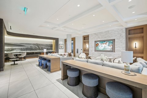 a lobby with couches and stools and a large window