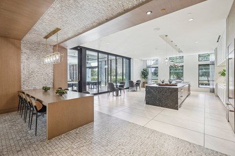 a large kitchen and dining area with a large island and glass doors