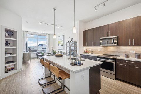 a kitchen with a large island and wooden floors and a large window