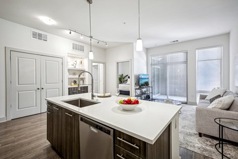 an open kitchen and living room with a white counter top