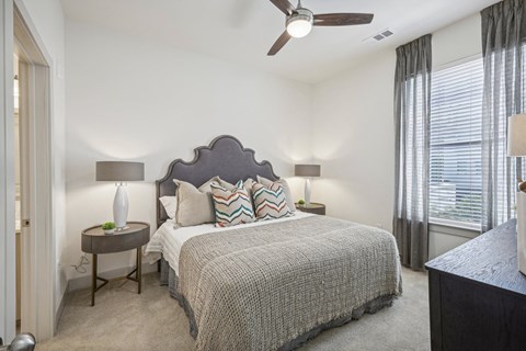 a bedroom with a bed and a ceiling fan