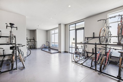a room with several bikes on display in front of glass doors