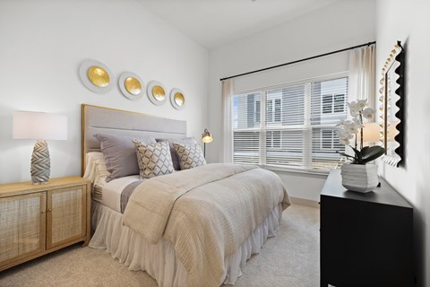A bedroom with a large bed and a mirror on the wall.