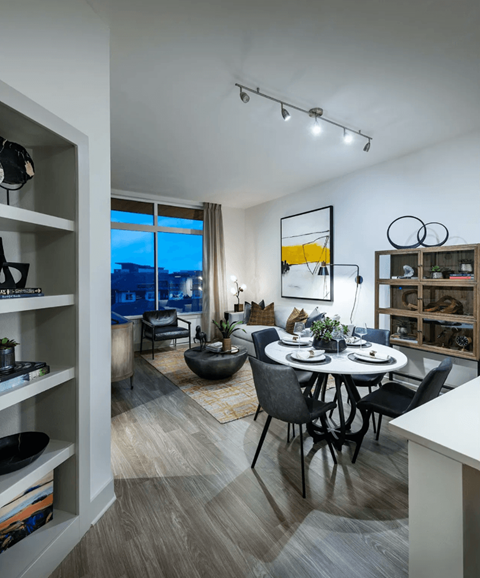 a living room and dining room with a table and chairs