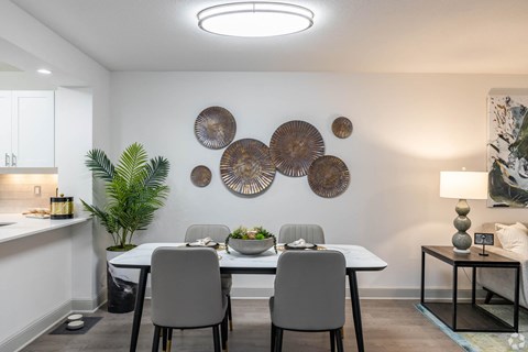 a dining room with a table and chairs and plates on the wall