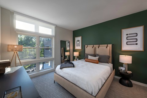 a bedroom with a large bed and a green accent wall