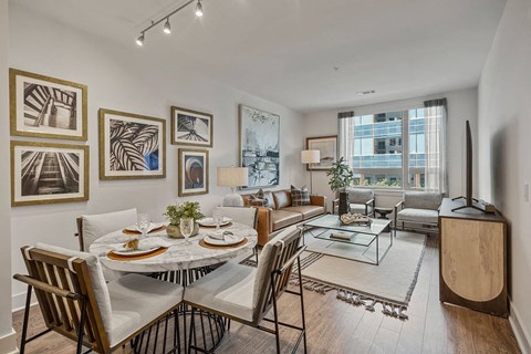 the living room of an apartment with a table and chairs