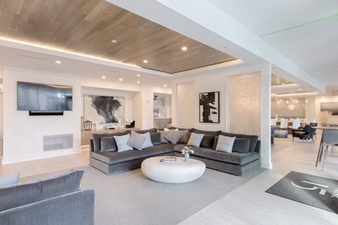 A modern living room with a grey sofa and a wooden ceiling.