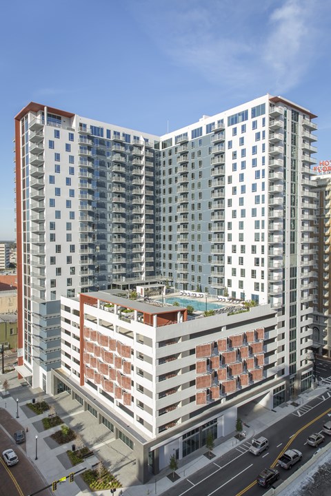 A modern multi-story building with a pool on the top floor.