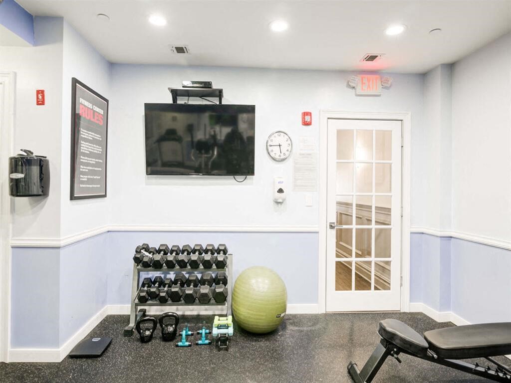 a gym with a television and weights on the floor