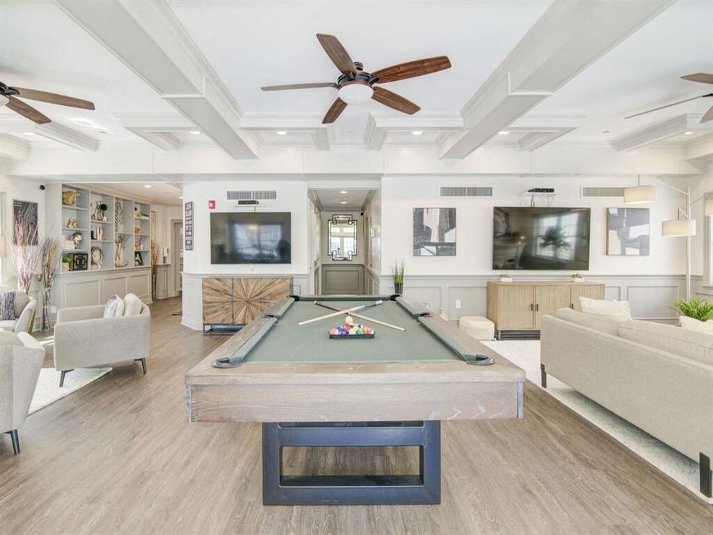 a living room with a pool table and a tv