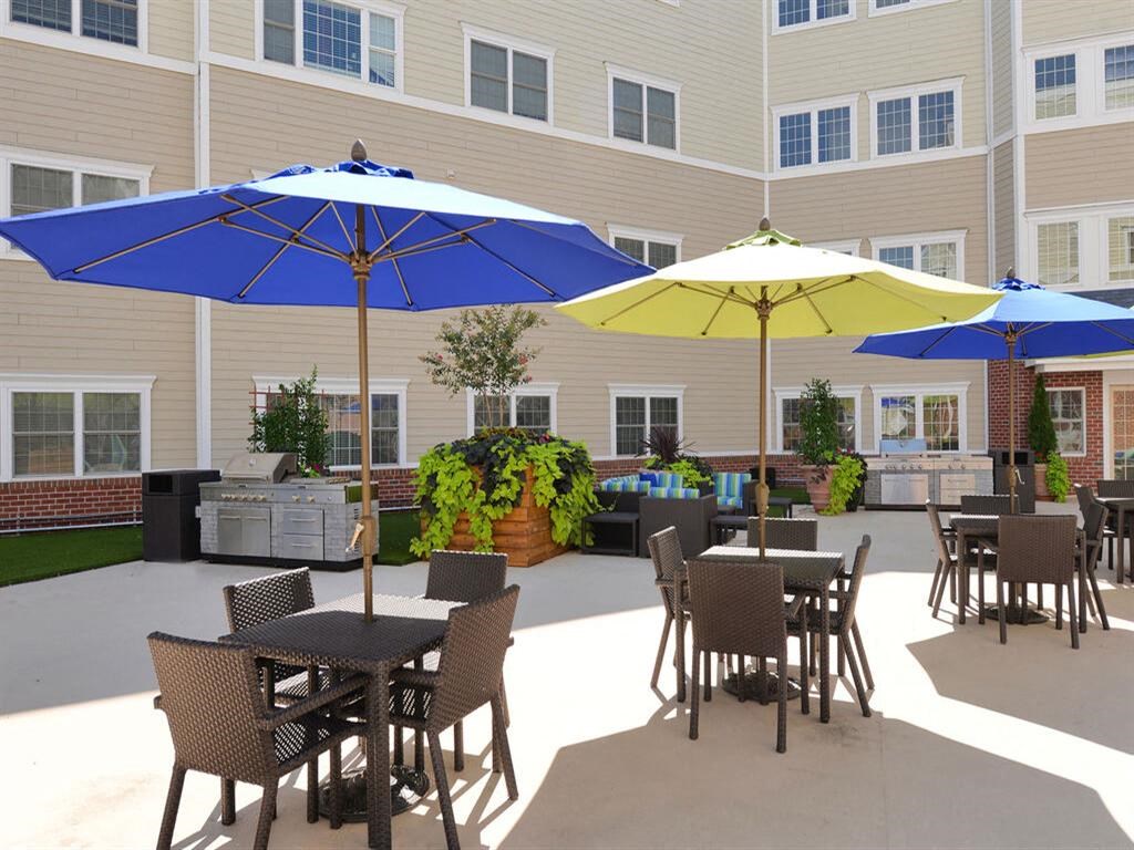 a patio with tables and umbrellas in front of a building