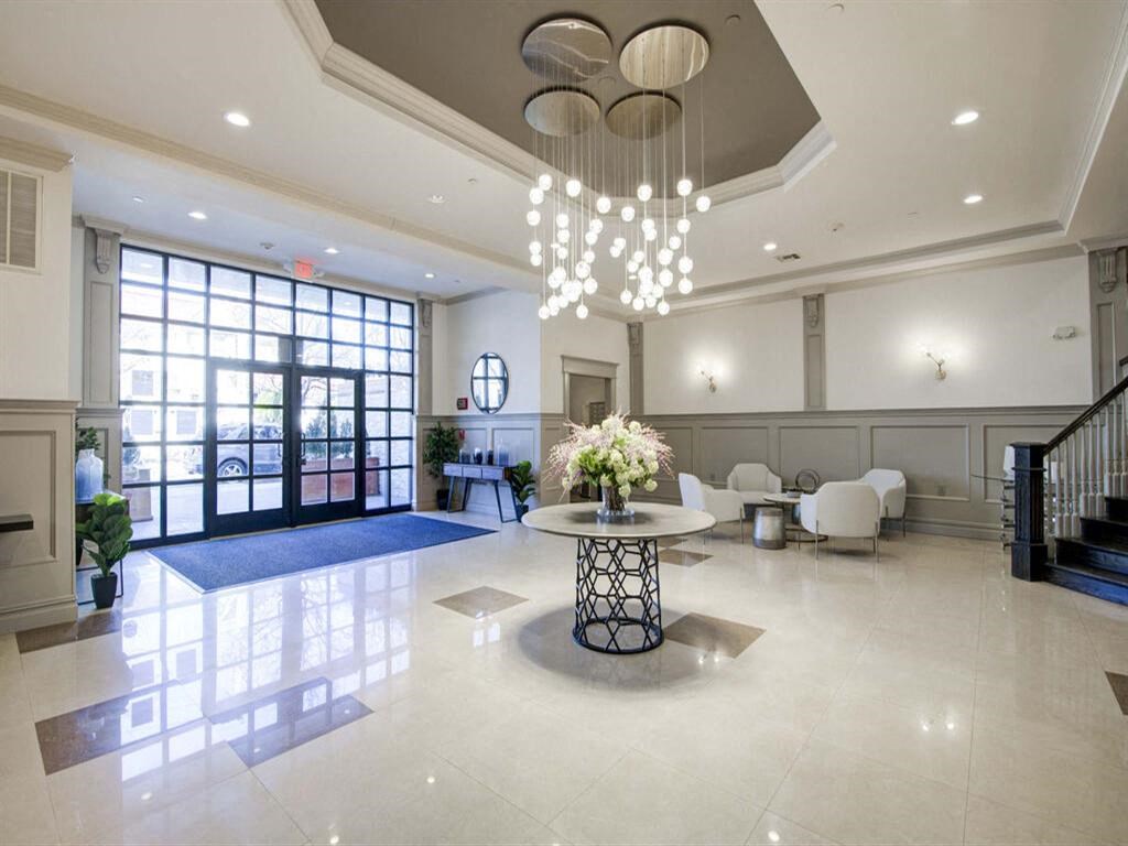 a large lobby with a table with a vase of flowers on it