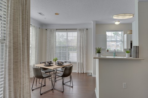 A dining room with a table set for four.