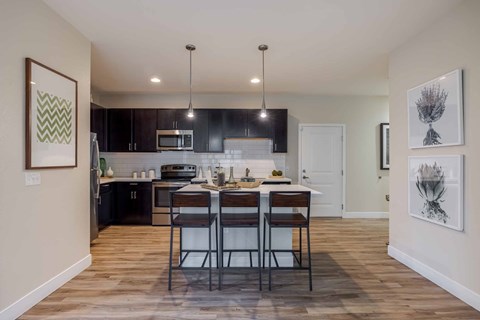 A kitchen with a table and chairs in the middle of the room.